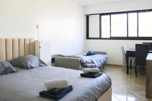- 2 lits dans une chambre avec une table et une salle à manger dans l'établissement Nice studio with garden near Paris, à Créteil