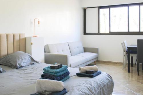 un salon avec un lit et un canapé dans l'établissement Nice studio with garden near Paris, à Créteil