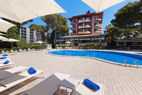 a pool at a hotel with lounge chairs and umbrellas at Hotel Pabisa Chico in Playa de Palma