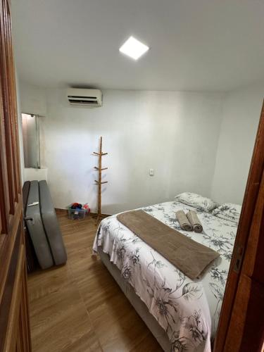 a bedroom with a bed and a wooden floor at Chalé aconchegante no Prado - Ar, Wi-Fi e ótima localização in Prado
