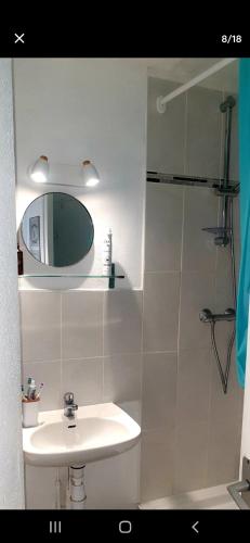 une salle de bain blanche avec un lavabo et un miroir dans l'établissement Appartement en résidence vue sur mer, au Barcarès