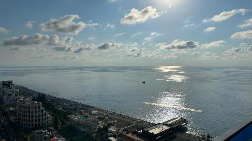 a view of the ocean with a boat in the water at ORBI CITY Batumi 2 bedrooms Panorama Sea & Mountain View in Batumi