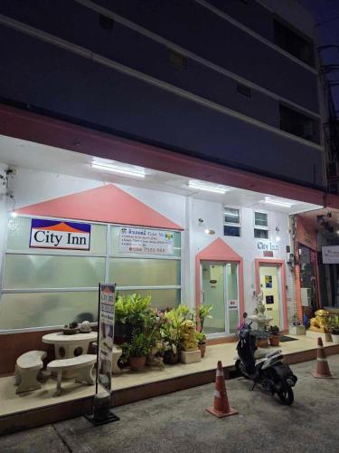 a city inn with a scooter parked in front of it at City Inn Udonthani in Udon Thani