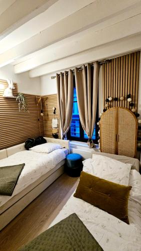 une chambre avec deux lits et une fenêtre dans l'établissement Maison Léonard, à Honfleur