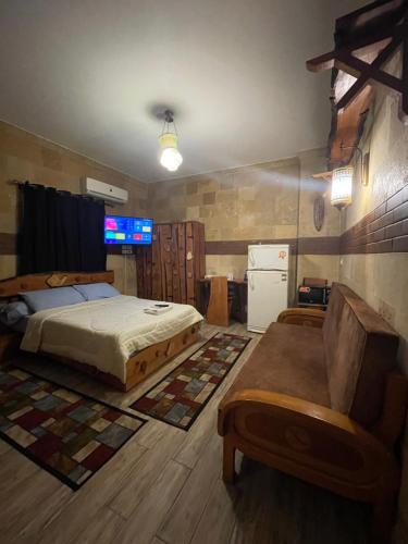 a bedroom with a bed and a couch and a refrigerator at Baraa house in Cairo