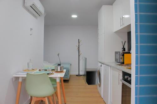 a kitchen with a table and chairs in a room at Apartamentos do Corgo in Vila Real