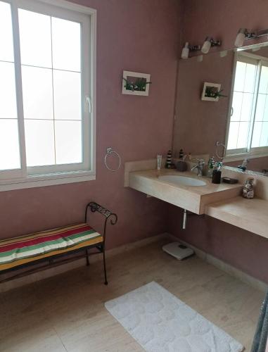 La salle de bains est pourvue d'un lavabo, d'un miroir et d'un banc. dans l'établissement Belle Villa piscine 4 personnes, à Vestric-et-Candiac