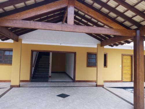 a house with a wooden roof and a staircase at Pousada Cedro Ilha Comprida in Ilha Comprida