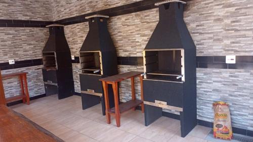 a room with three ovens in a brick wall at Pousada Cedro Ilha Comprida in Ilha Comprida