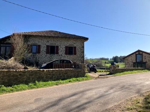 a house with a motorcycle parked next to a road at Chambres d'hôtes Le tour du Lot in Gorses