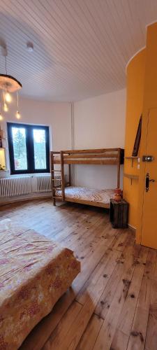 a bedroom with two bunk beds and a wooden floor at Les Favouilles - Gîte & Chambres d hôtes in Dauphin