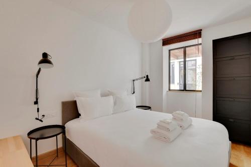 une chambre avec un lit blanc avec des serviettes dessus dans l'établissement Pick A Flat's Apartments in Montmartre - Rue des Cottages, à Paris