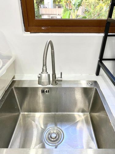 a stainless steel sink in a kitchen with a window at Nature Home Suites in Lunao