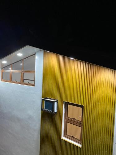 a yellow wall with a tv on the side of a building at Nature Home Suites in Lunao