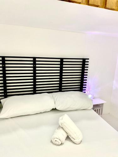 a white bed with a towel laying on it at Nature Home Suites in Lunao
