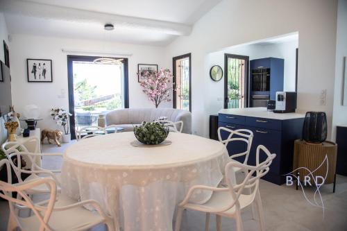 une cuisine et un salon avec une table et des chaises dans l'établissement Sumptuous villa with sea view and its renovated outbuilding in the heart of, à Théoule-sur-Mer