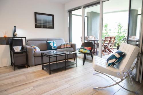 un salon avec un canapé et une table dans l'établissement Magnificent apartment on the ground floor and next to the sea, à Villeneuve-Loubet