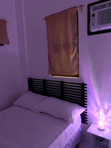 a bedroom with a bed and a window with lights at Nature Home Suites in Lunao