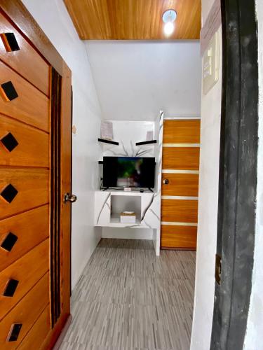 a small room with a tv and a door at Nature Home Suites in Lunao