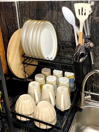 a bunch of dishes in a dish rack next to a sink at Nature Home Suites in Lunao