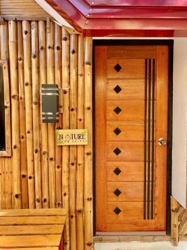 a wooden door with a sign on a building at Nature Home Suites in Lunao