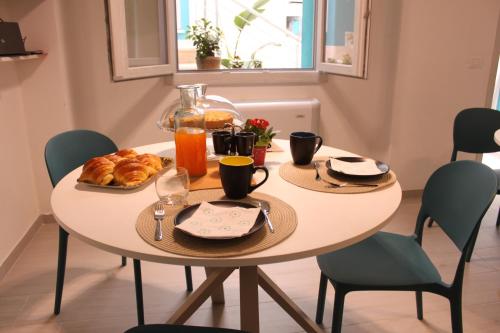 a table with a breakfast of croissants and orange juice at La Pura Vida in Castelsardo
