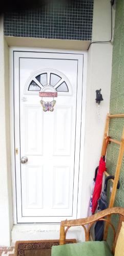 a white door with a sign on it next to a chair at Alojamento local Os Maias in Mirandela