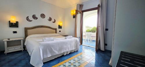 a bedroom with two beds and a door to a patio at Hotel Myage in Ischia