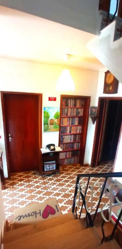 a living room with a staircase and bookshelves at Alojamento local Os Maias in Mirandela