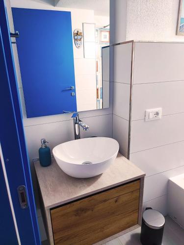 a bathroom with a white sink and a mirror at La Pura Vida in Castelsardo