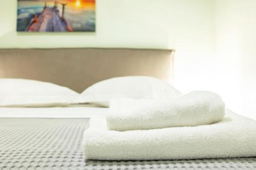 a pile of towels sitting on top of a bed at Aris123 by Smart Cozy Suites - Apartments in the heart of Athens - 5 minutes from metro - Available 24hr in Athens