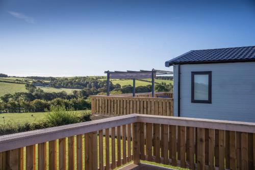 una terraza de madera junto a una casa pequeña en Crofthead Holiday Park, en Ayr