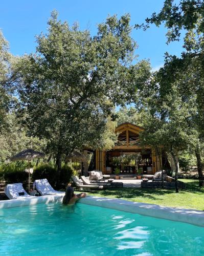 a person in a swimming pool in front of a house at Luz Charming Houses in Fátima