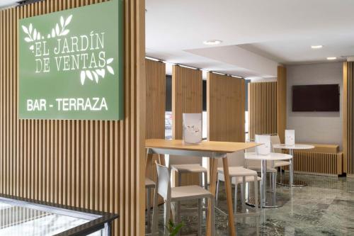 a restaurant with tables and chairs and a sign on the wall at NH Madrid Ventas in Madrid