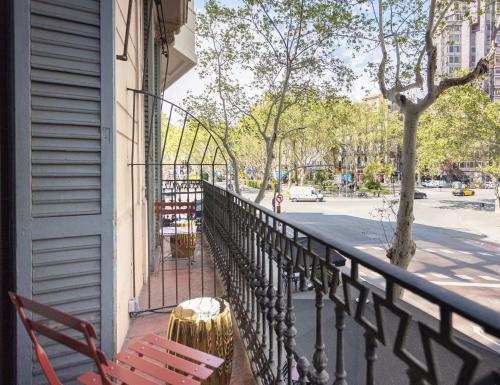 バルセロナにあるHotel Casa Trafalgar Barcelonaの赤い椅子2脚と柵のあるバルコニー