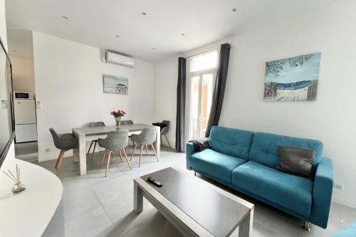 un salon avec un canapé bleu et une table dans l'établissement Apartment of 38 m2 with sea view in Cannes, à Cannes