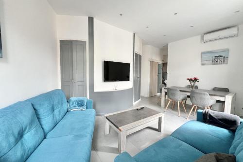 un salon avec un canapé bleu et une table dans l'établissement Apartment of 38 m2 with sea view in Cannes, à Cannes