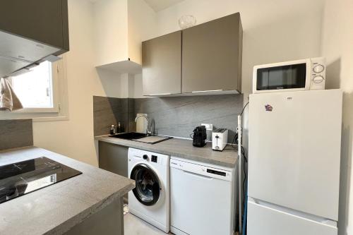 Il comprend une cuisine équipée d'un lave-linge et d'un réfrigérateur blanc. dans l'établissement Apartment of 38 m2 with sea view in Cannes, à Cannes