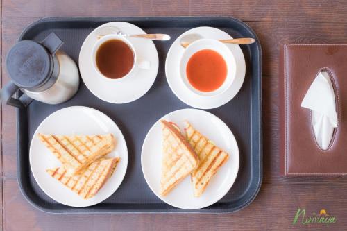 ein Tablett mit Waffeln und zwei Tassen Tee in der Unterkunft Nirmaya Resort in Kanatal