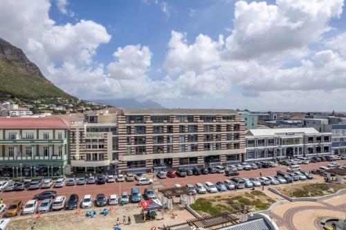 una ciudad con coches aparcados en un estacionamiento en 'Just Beachy' Muizenberg Beach Apartment, en Muizenberg