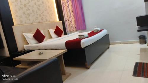 a small bed with red pillows in a room at Hotel Shanti Niketan By Nexottel in Deoghar