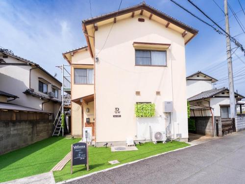 a white house with a sign in front of it at happyStay 凛 in Ichimonji