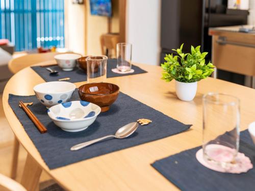 a wooden table with bowls and spoons on it at happyStay 凛 in Ichimonji