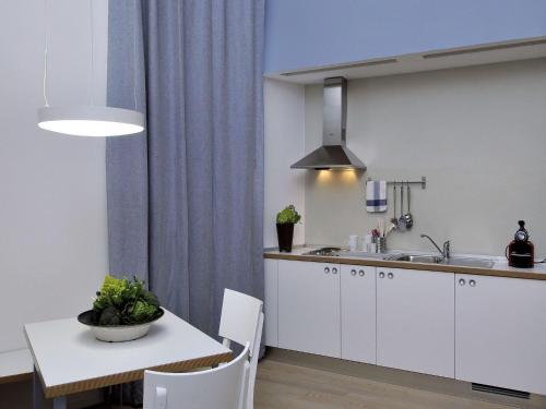 a kitchen with white cabinets and a table and a sink at Villa Aruch in Florence