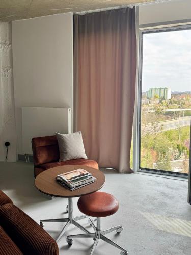 a room with a table and a chair and a window at E64 Wieża Wrocław in Wrocław