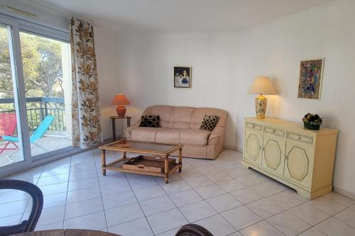 un salon avec un canapé et une table dans l'établissement Nice 2 room with pool and balcony in Fréjus, à Fréjus