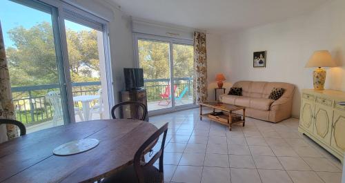 un salon avec une table et un canapé dans l'établissement Nice 2 room with pool and balcony in Fréjus, à Fréjus
