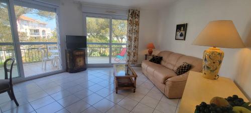 un salon avec un canapé et une télévision dans l'établissement Nice 2 room with pool and balcony in Fréjus, à Fréjus