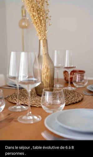 une table avec des verres et un vase avec des fleurs dedans dans l'établissement Le bohème, à Sanary-sur-Mer