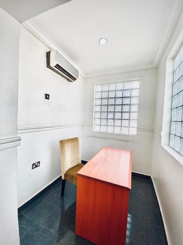 an empty room with a wooden table and a chair at Starluxury Apartments and Suites in Mama